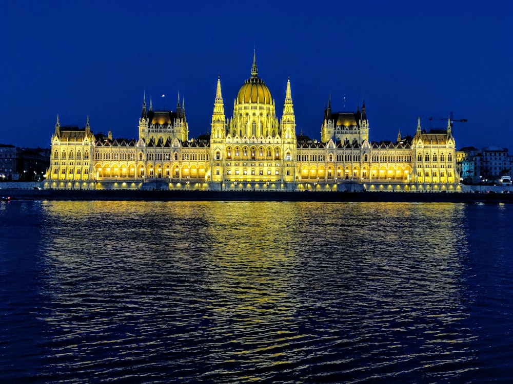 white concrete building near body of water during night time