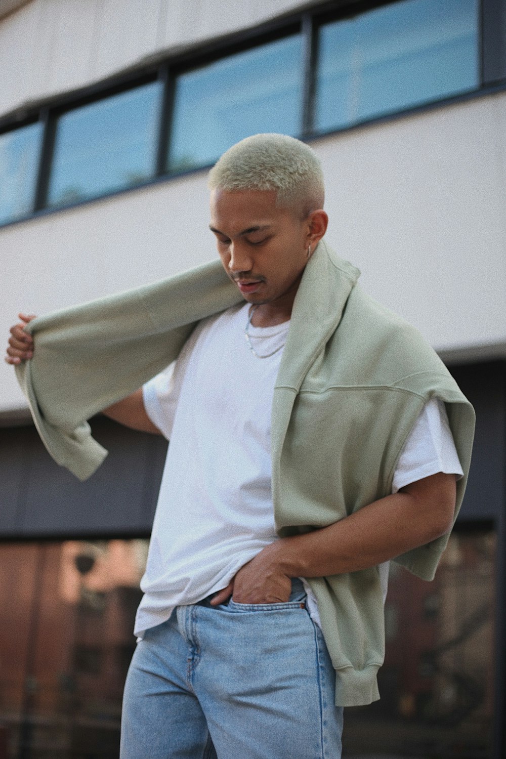 Homme en polo blanc et jean en denim bleu tenant du textile blanc