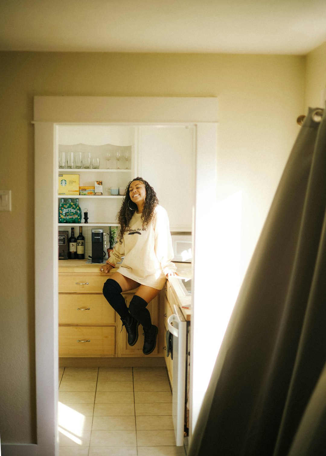 woman in white long sleeve shirt and black skirt standing beside white wooden shelf