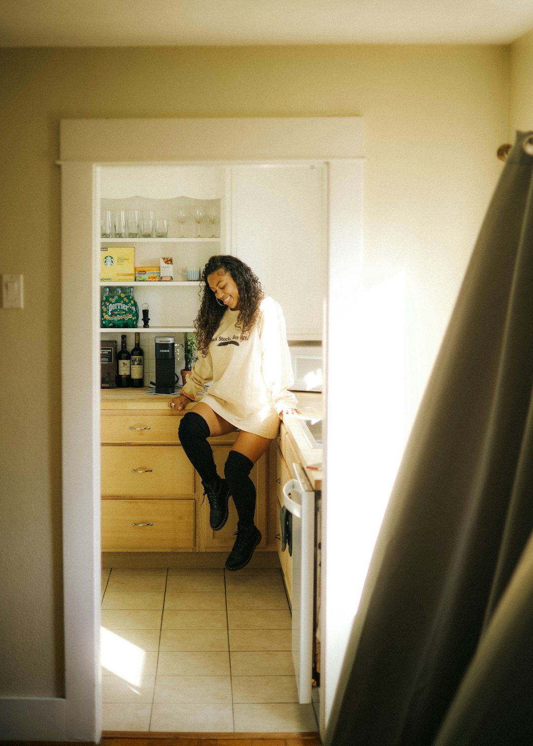 woman in white long sleeve shirt and black skirt standing beside white wooden shelf