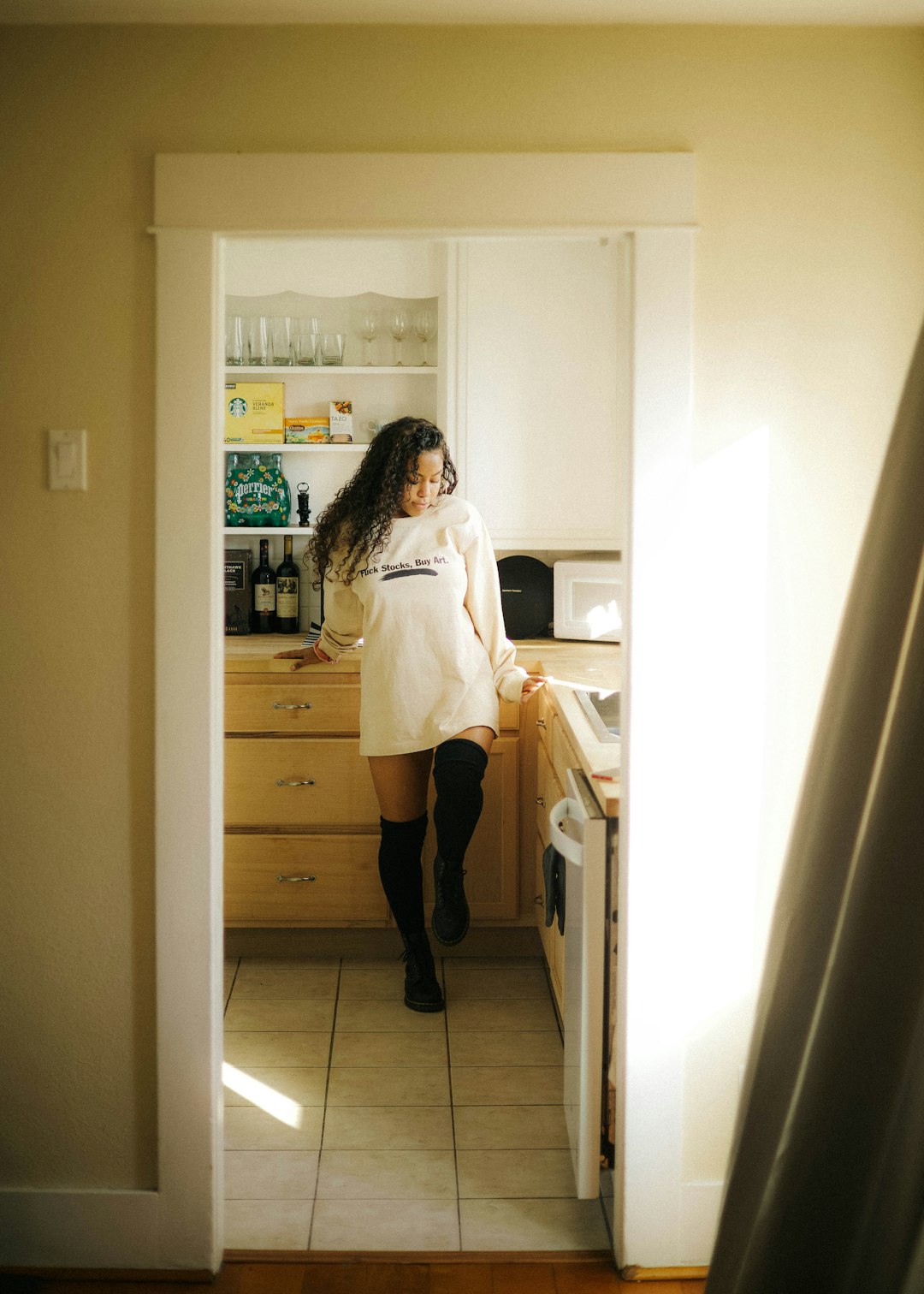 woman in white robe standing in front of white wooden cabinet