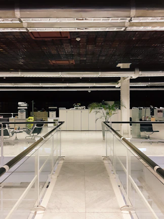 Workers fitting a stylish glass partition in a contemporary office space.
