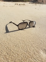 Stylish sunglasses resting on a summer beach towel with a sunny background