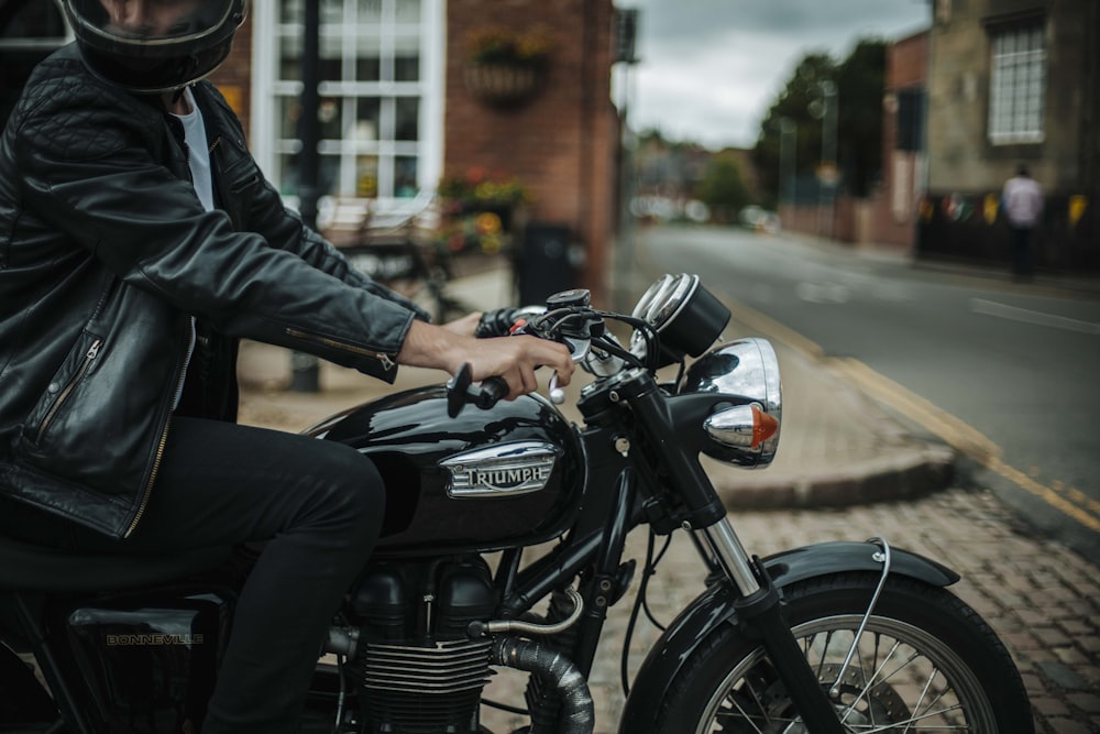 man in black leather jacket riding black motorcycle during daytime