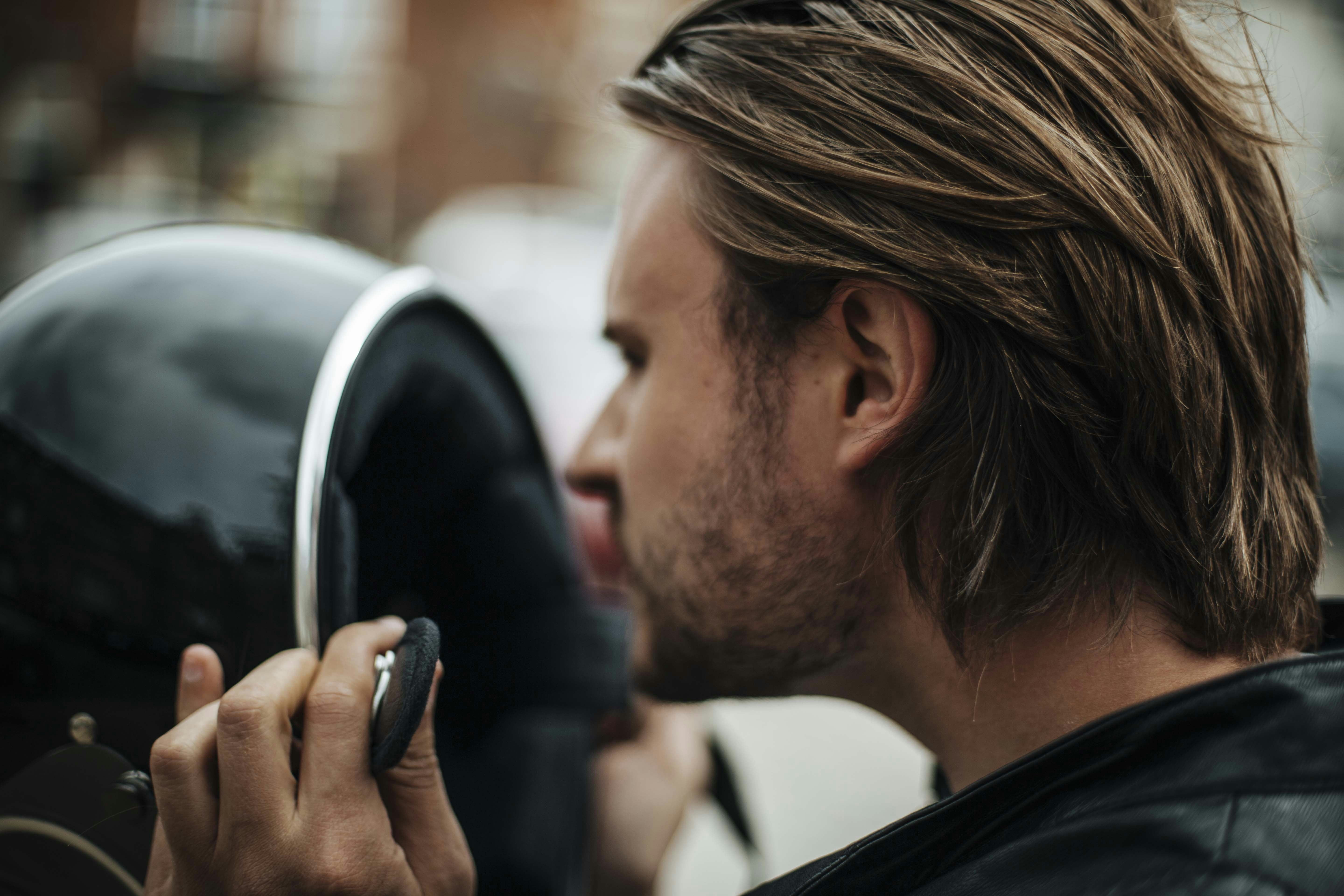 man in black shirt holding black smartphone