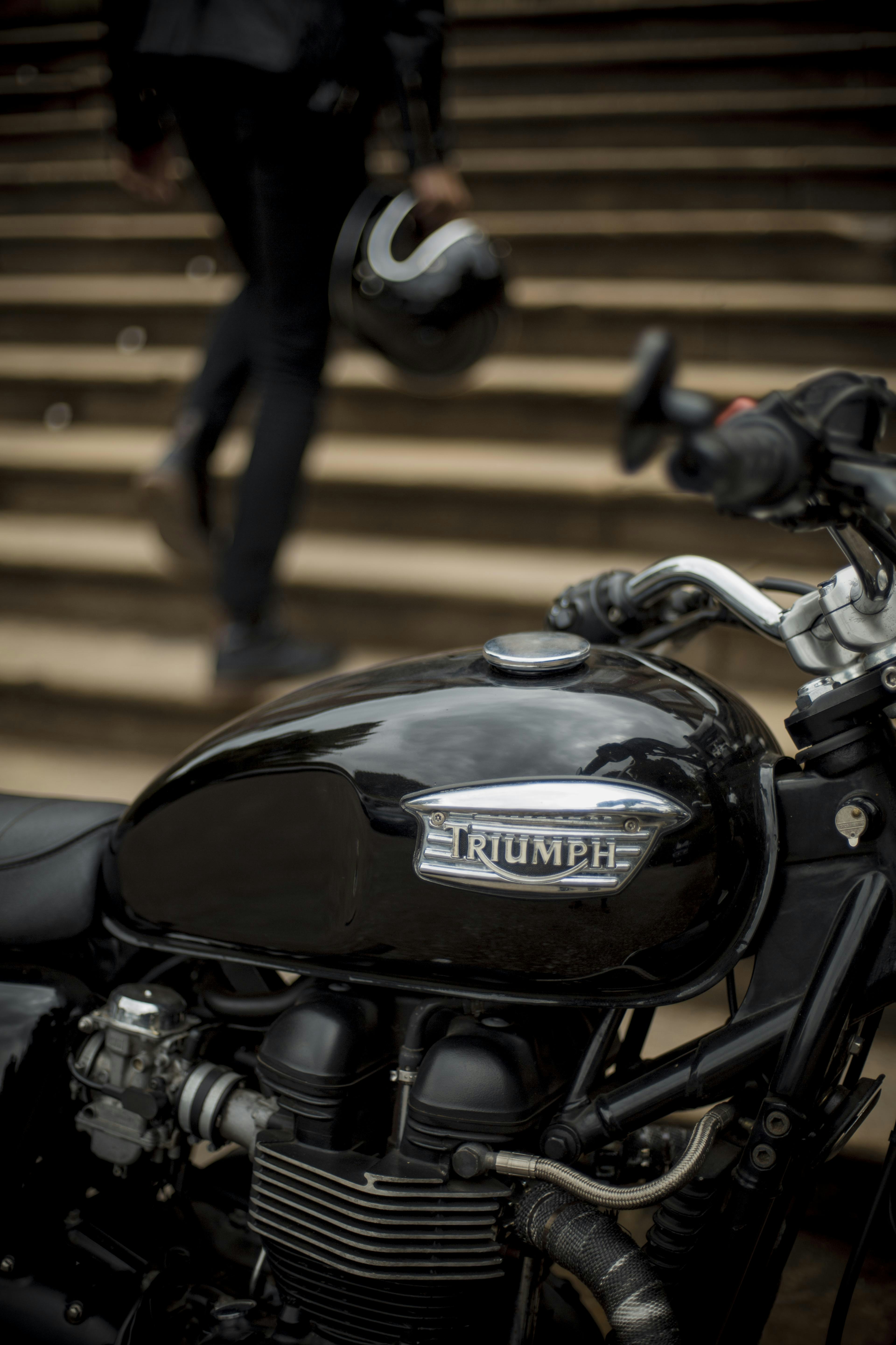 Motocicletta nera e argento parcheggiata sul pavimento di legno marrone