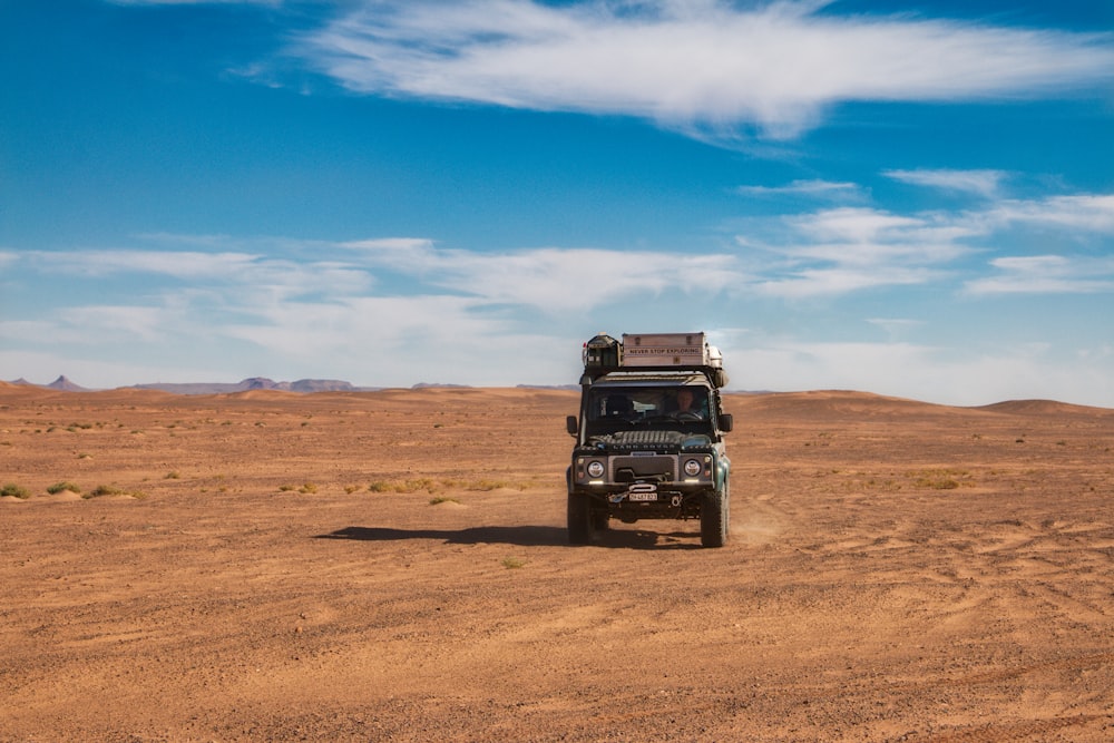 black jeep wrangler on brown field under blue sky during daytime