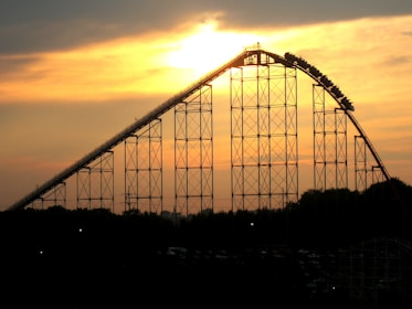 A thrilling roller coaster twisting through the sky at sunset.