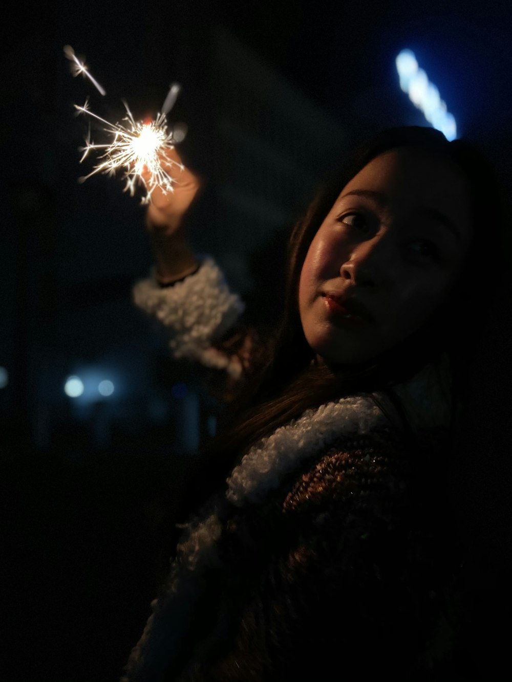 woman in black and white floral shirt holding sparkler