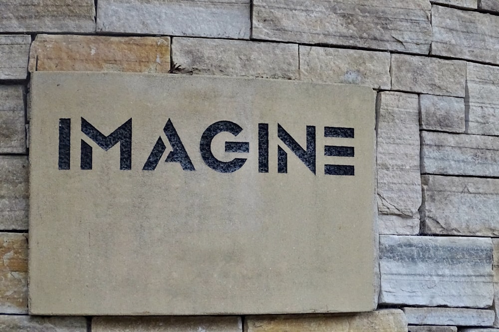 a stone sign that reads imagine on it