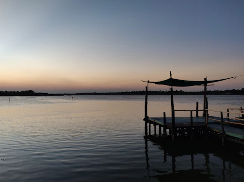 A serene view of the Taj Lake from a cozy balcony at Jalvihar during sunset.