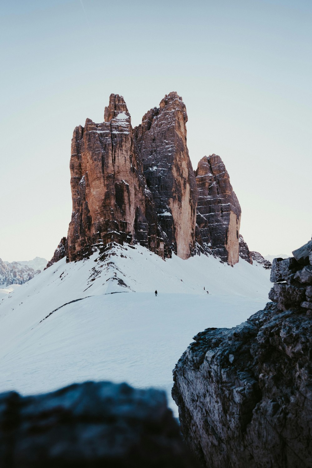 brown rocky mountain covered by snow during daytime