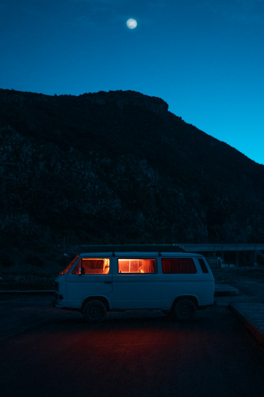 white van parked near body of water during daytime