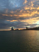Sunset over the Caudan Waterfront showing modern buildings against a fiery sky.