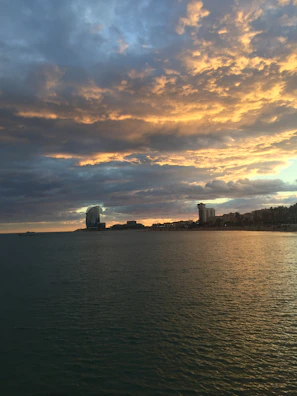 Sunset over the Caudan Waterfront showing modern buildings against a fiery sky.