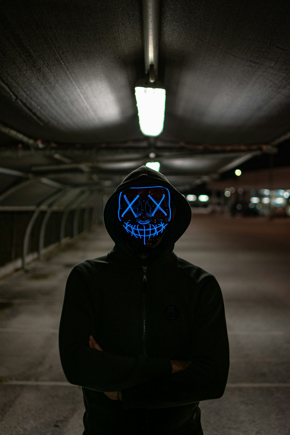 man in black hoodie wearing blue and white mask