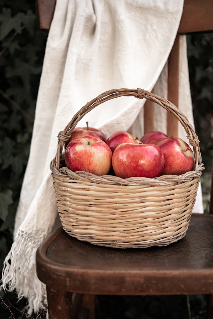 Ripe red apples gathered in a woven basket