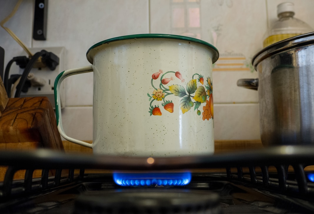 white and pink floral cooking pot on stove