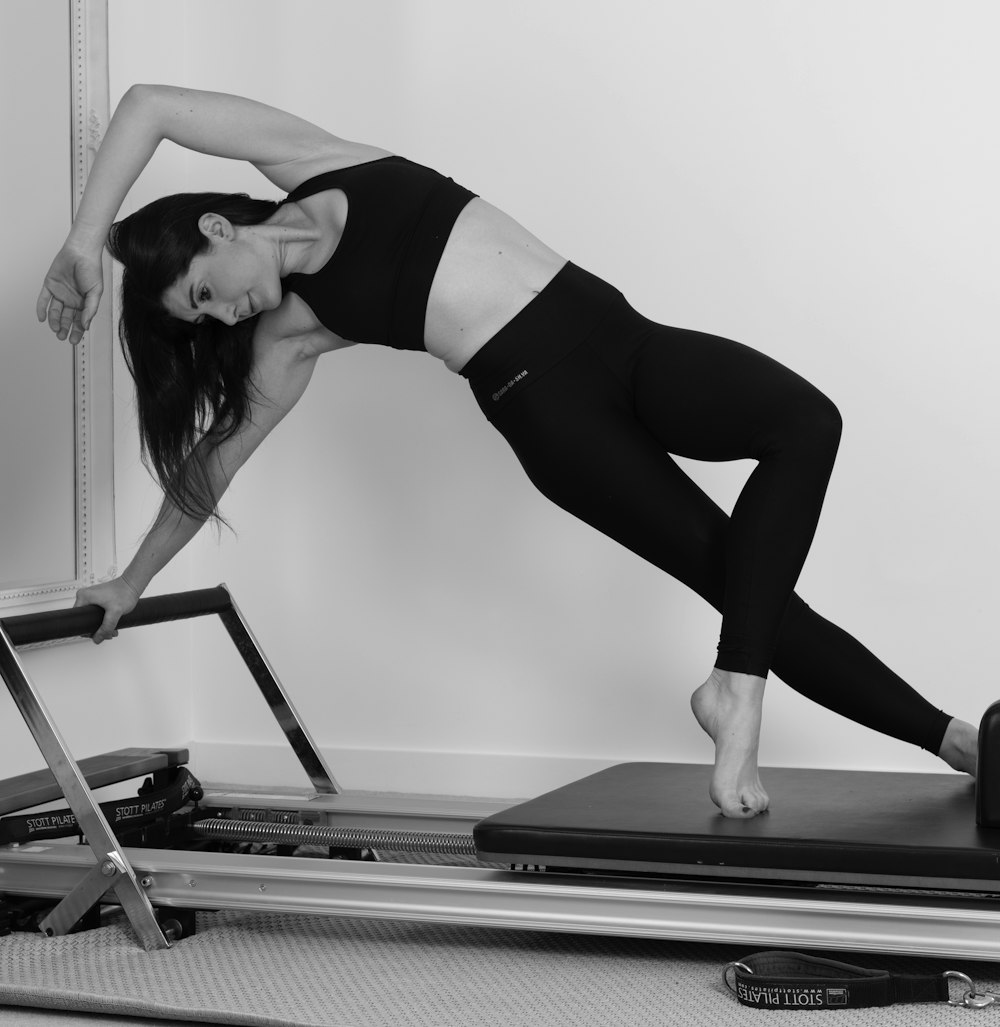 woman in black sports bra and black leggings doing yoga