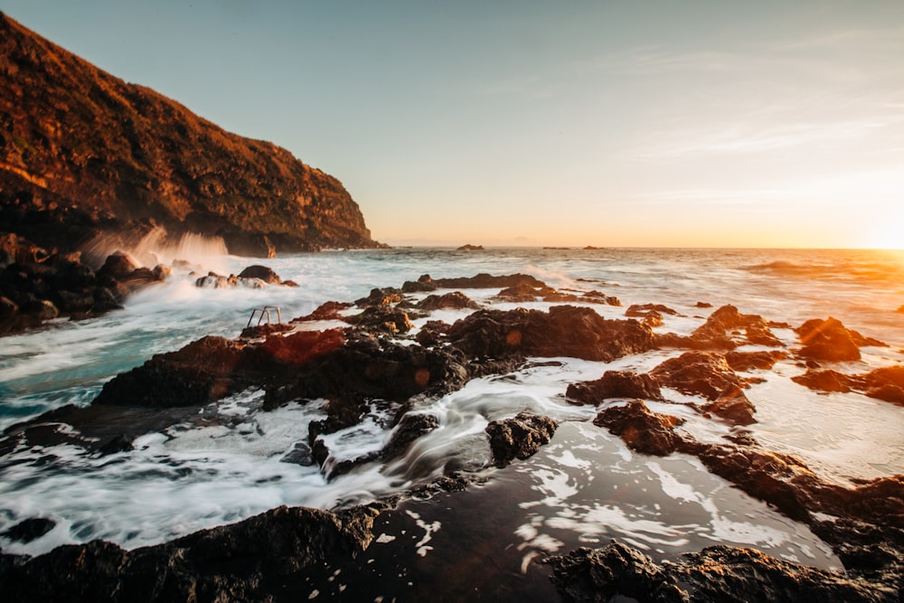 rocky shore with water waves during daytime