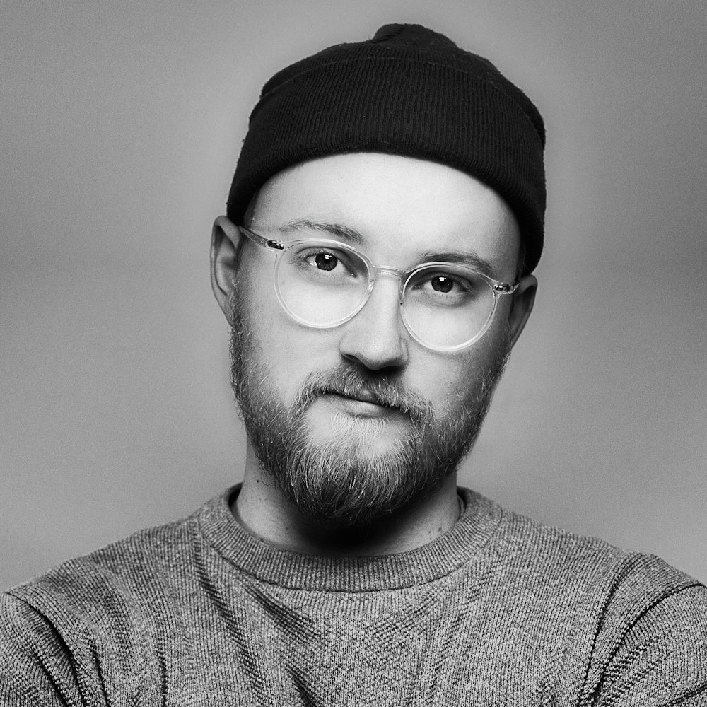 man in black knit cap and black framed eyeglasses