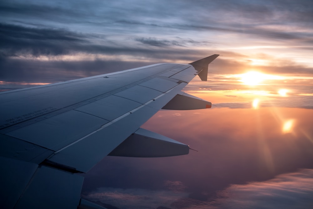 Ala blanca del avión durante la puesta del sol