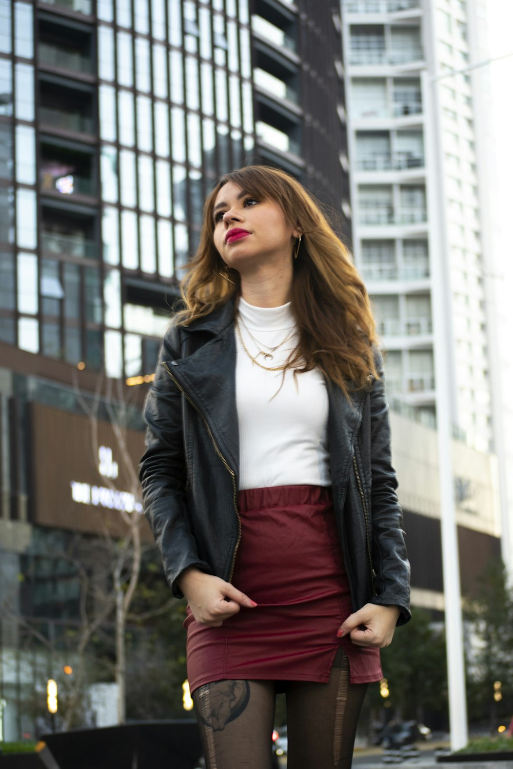 woman in black leather jacket and red dress