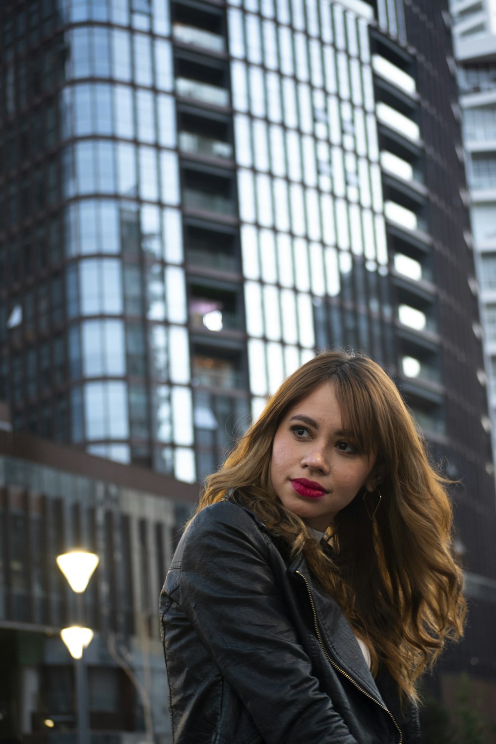 woman in black jacket standing near building during daytime