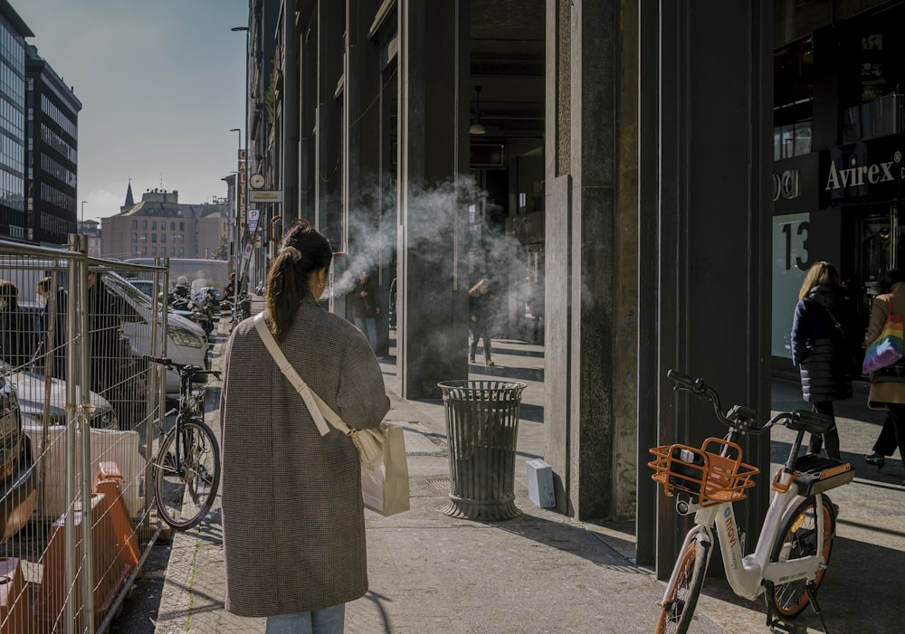 woman in white coat standing near brown wooden door during daytime