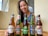 Happy woman unpacking a box of assorted beverages at her kitchen table