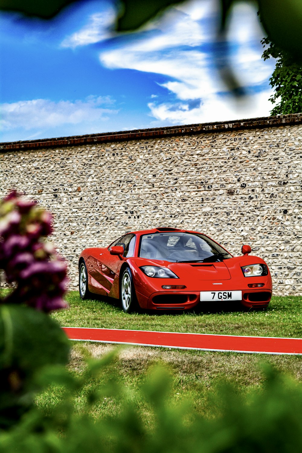 red porsche 911 parked on green grass field during daytime