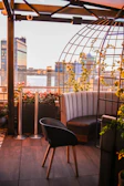 An urban rooftop terrace with modern seating and panoramic city views at sunset.