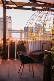 A sleek rooftop deck bathed in soft evening light with modern seating and lush green planters.