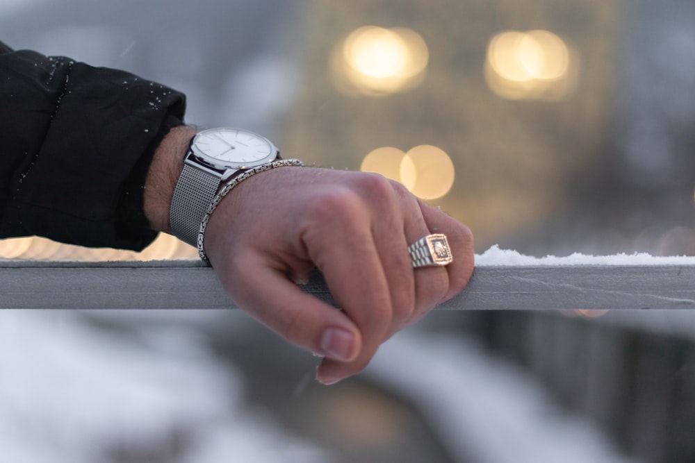 person wearing silver and white analog watch