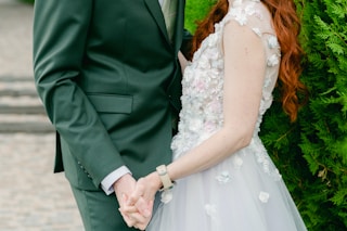 man in black suit jacket and woman in white floral dress