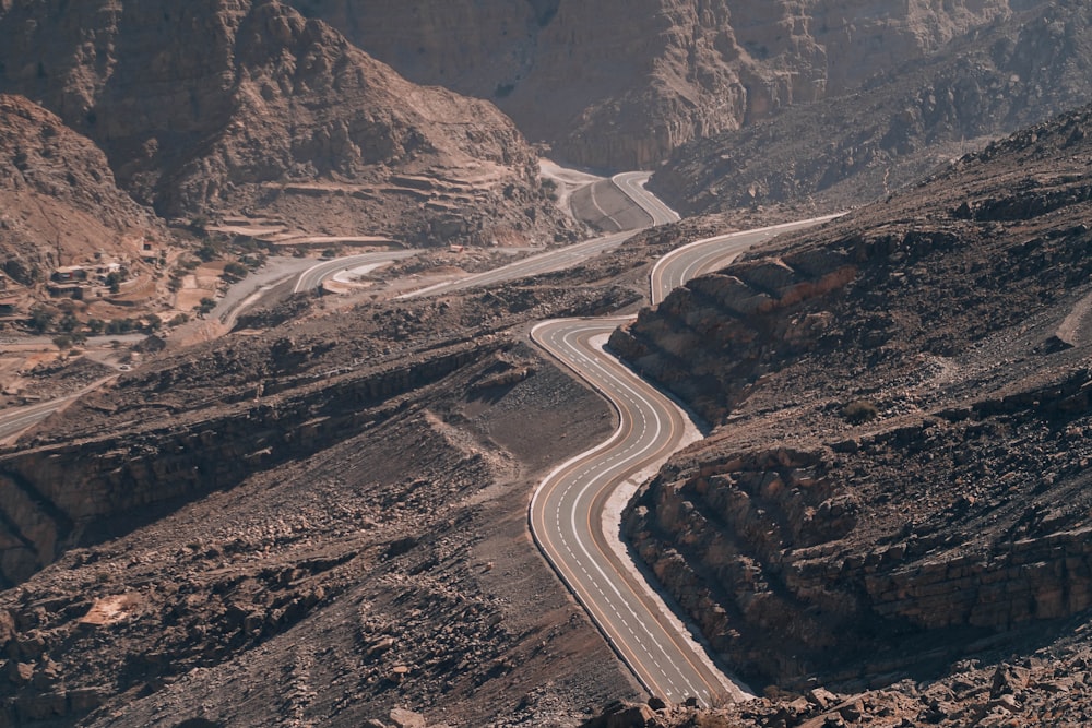 gray asphalt road between brown mountains during daytime