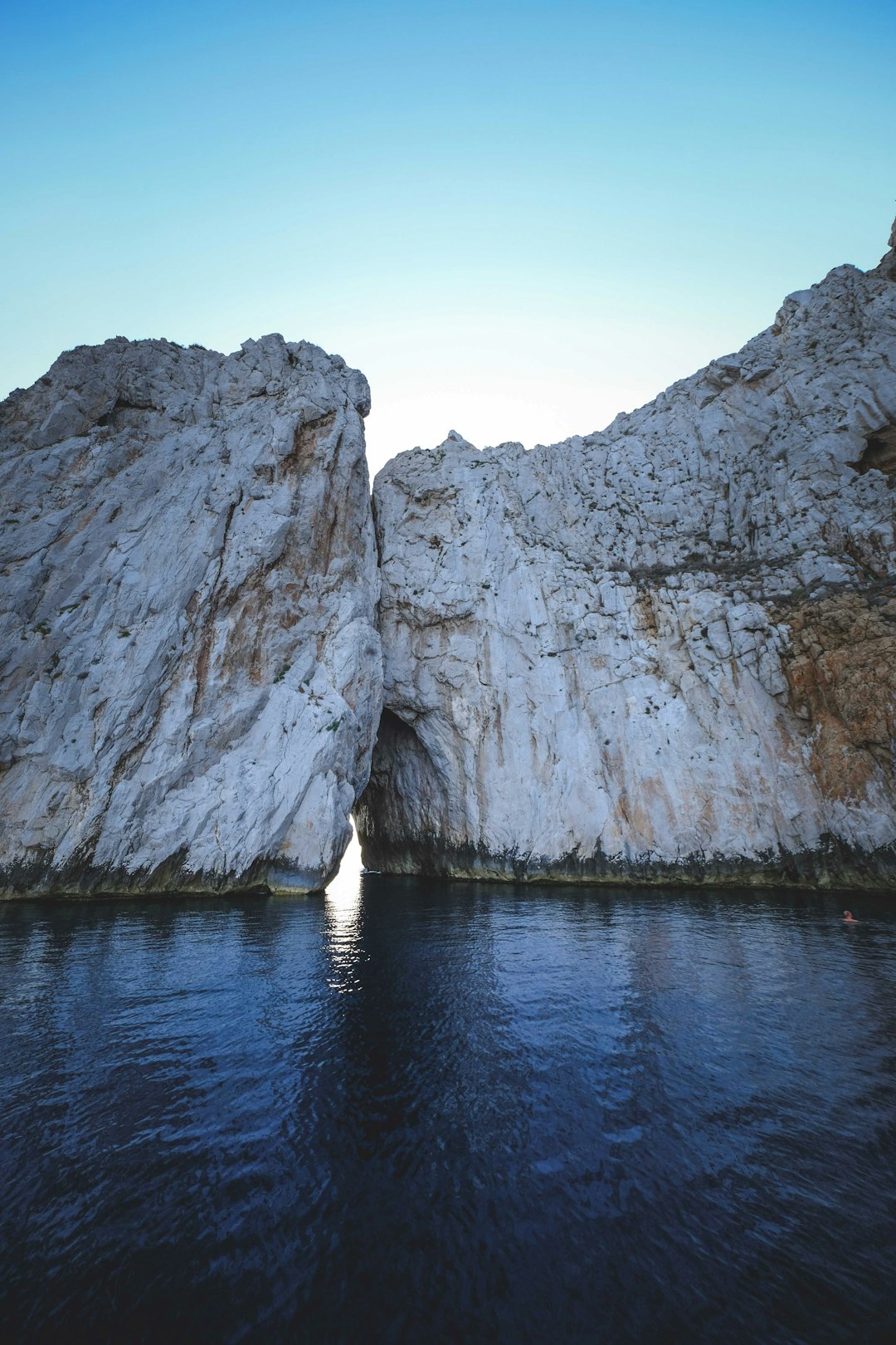 gray rock formation on blue water during daytime