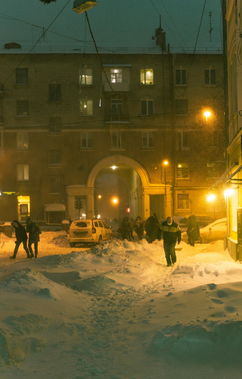 people walking on snow covered road near brown concrete building during daytime