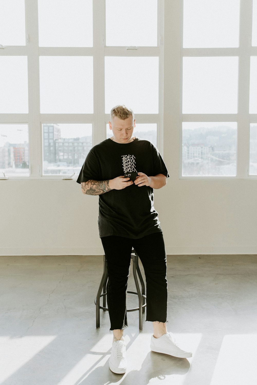 man in black crew neck t-shirt and black pants sitting on black seat