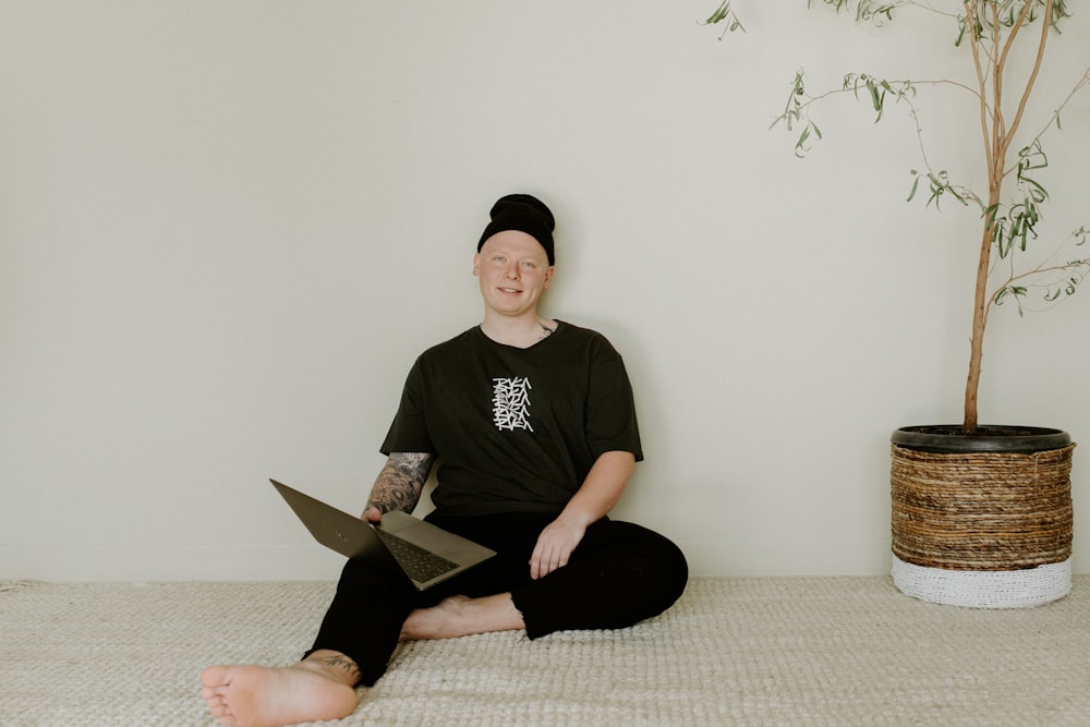 man in black crew neck t-shirt sitting on gray sofa