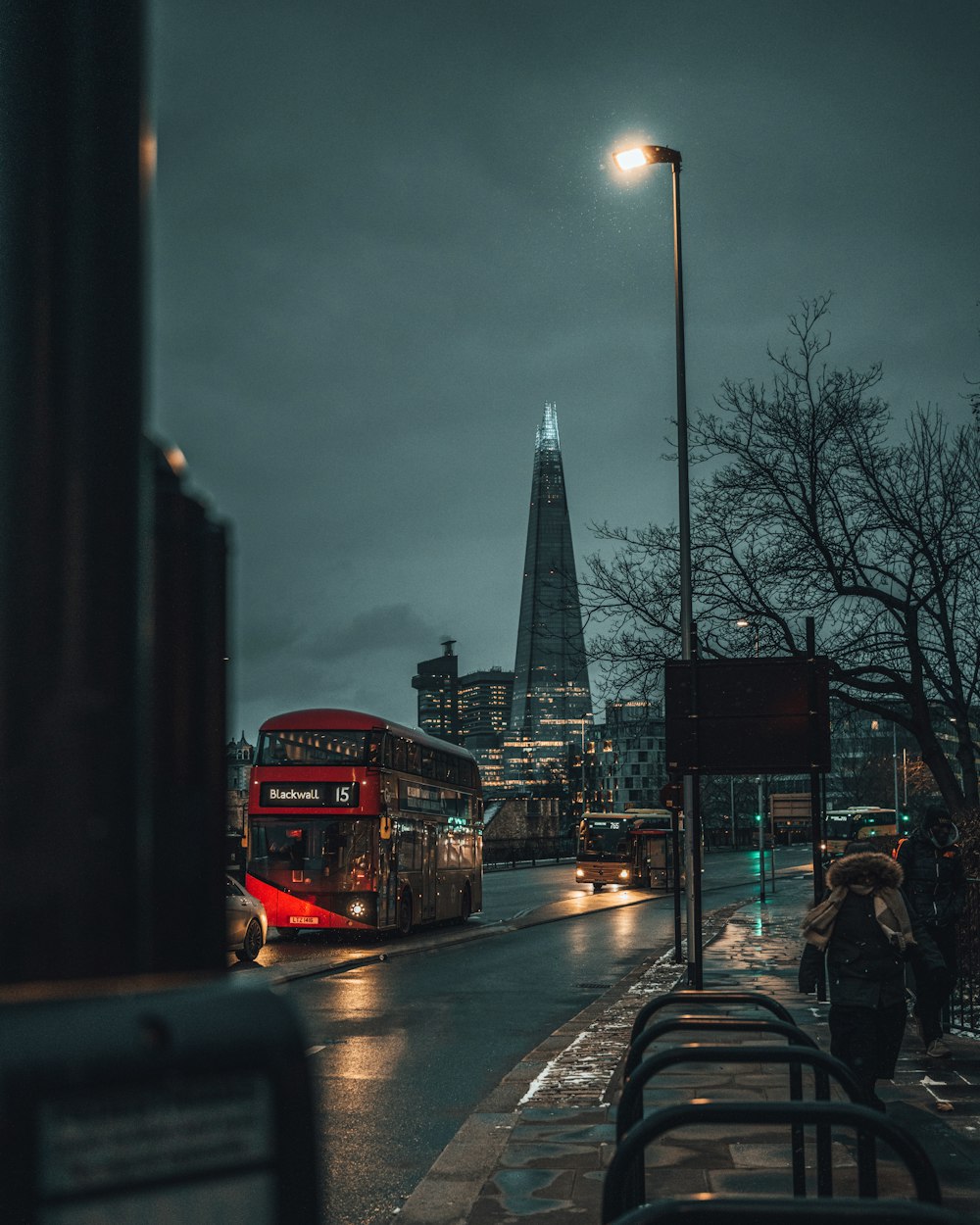 people walking on sidewalk near city buildings during night time