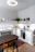 Cozy modern kitchen with light wood PVC flooring and soft natural light streaming through the window.
