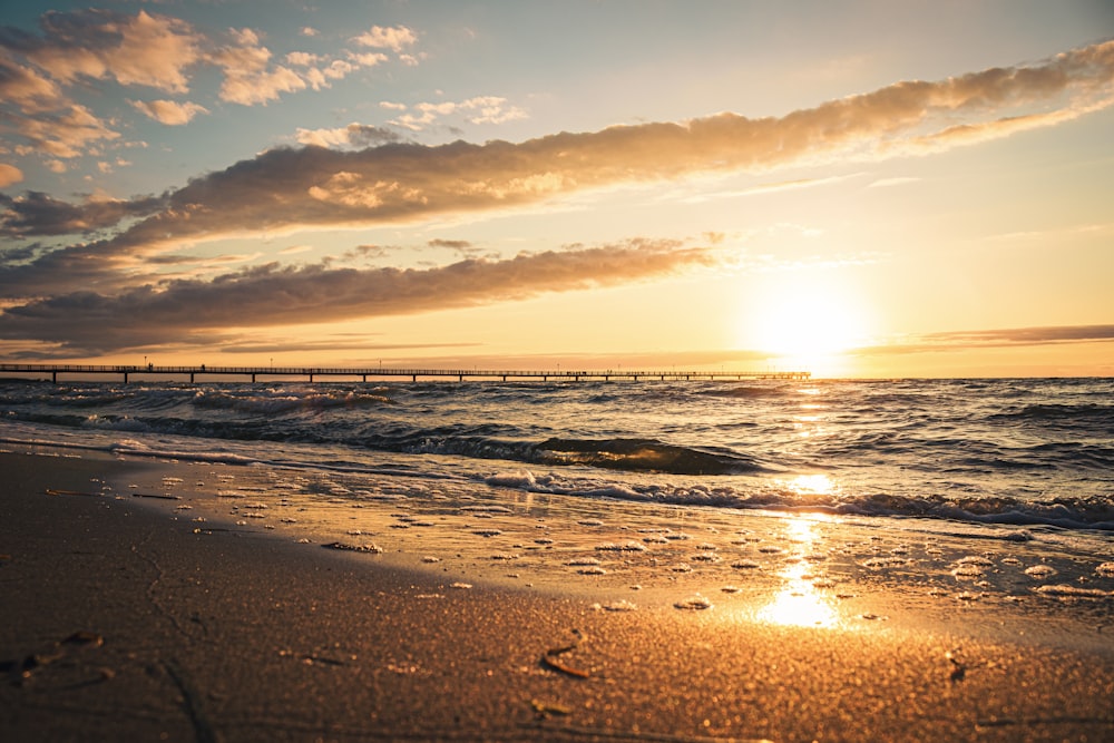 sea waves crashing on shore during sunset