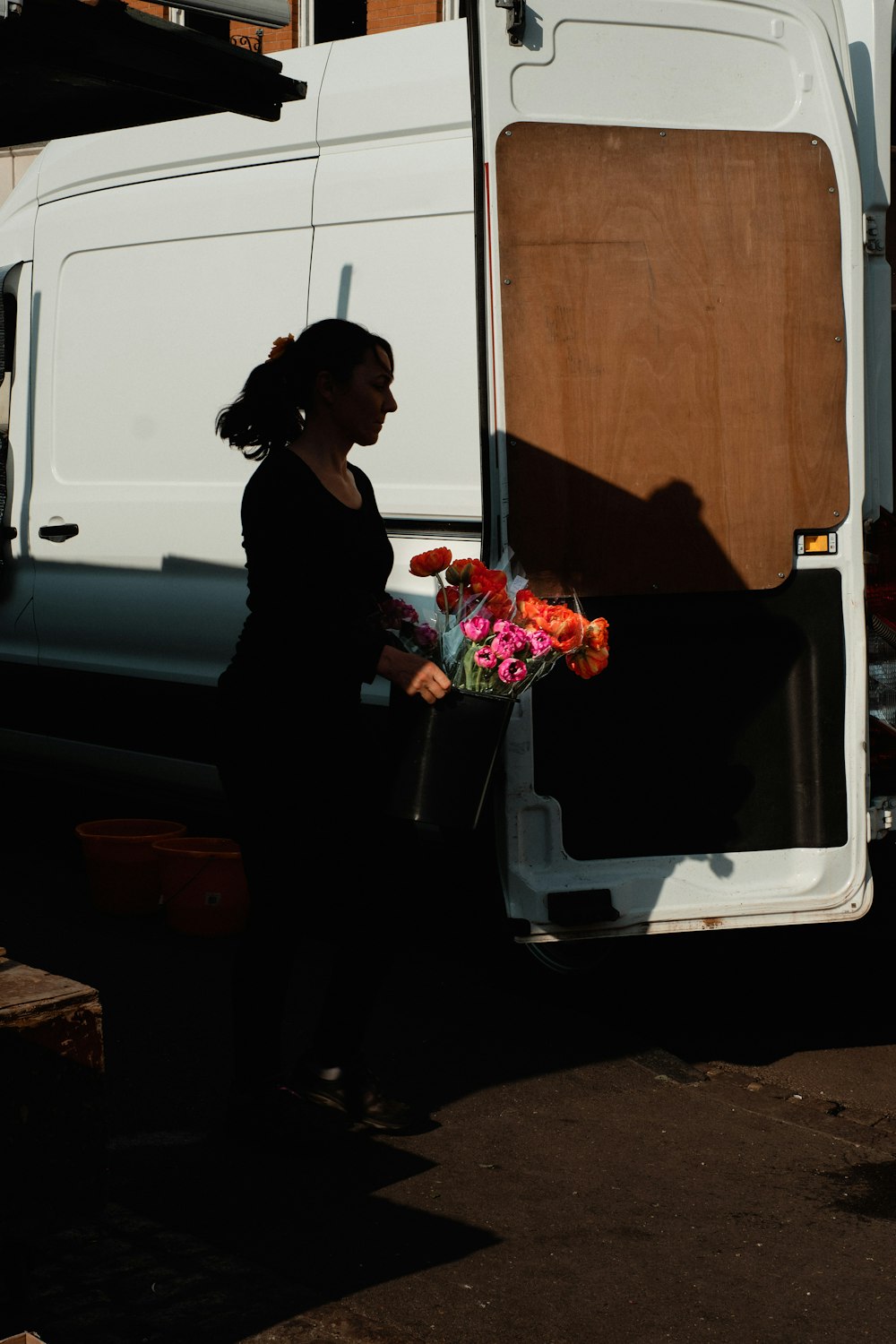 woman in black dress holding bouquet of flowers