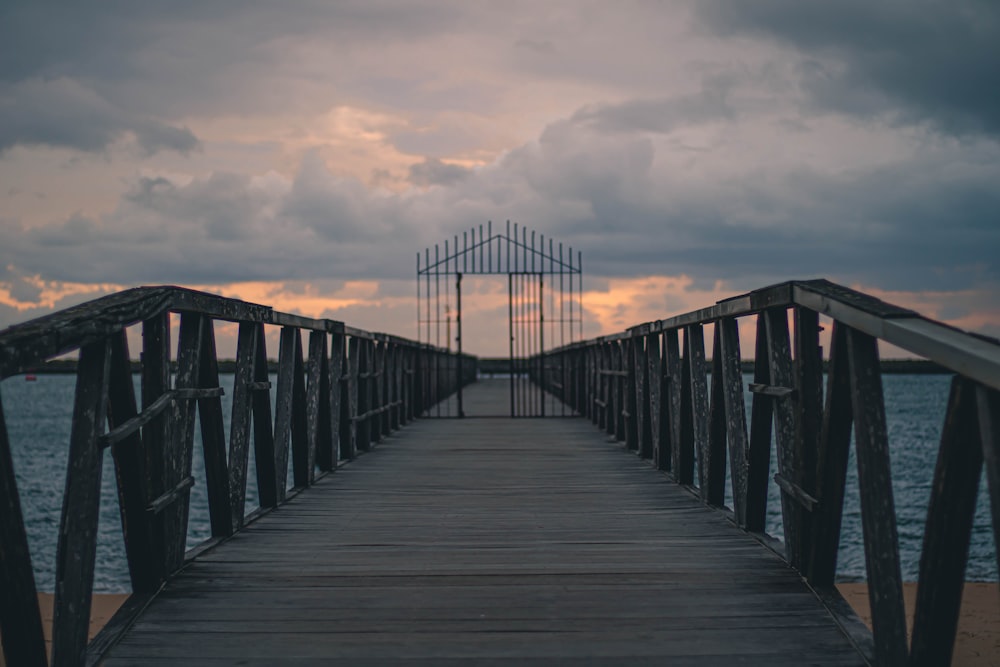 brown wooden bridge under cloudy sky during daytime