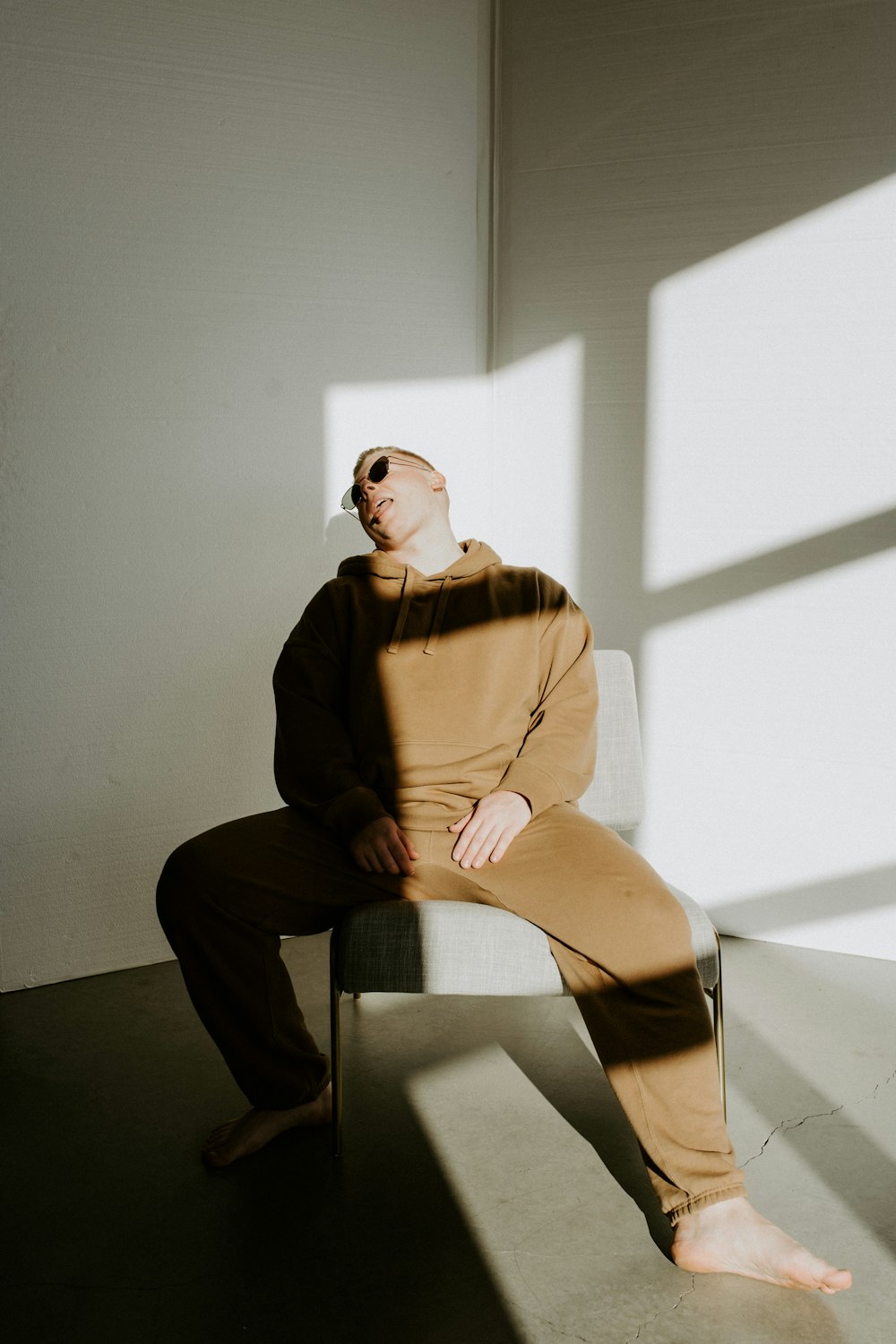 woman in brown long sleeve shirt and black pants sitting on white bench