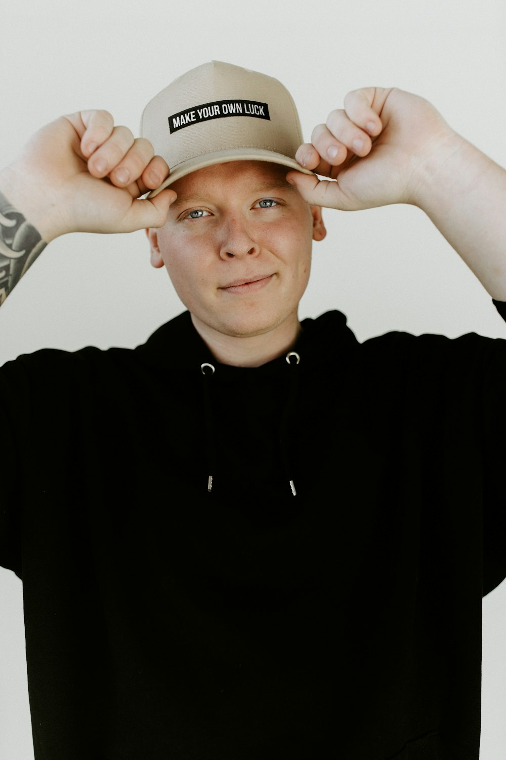 Homme en polo noir portant une casquette blanche