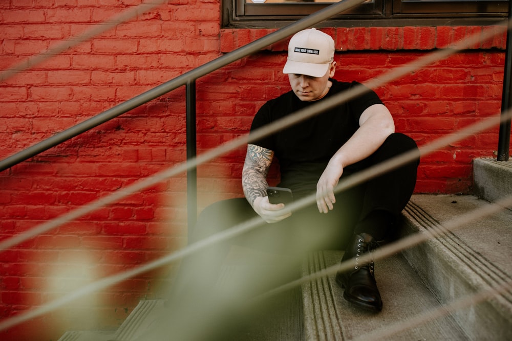 man in black crew neck t-shirt sitting on stairs