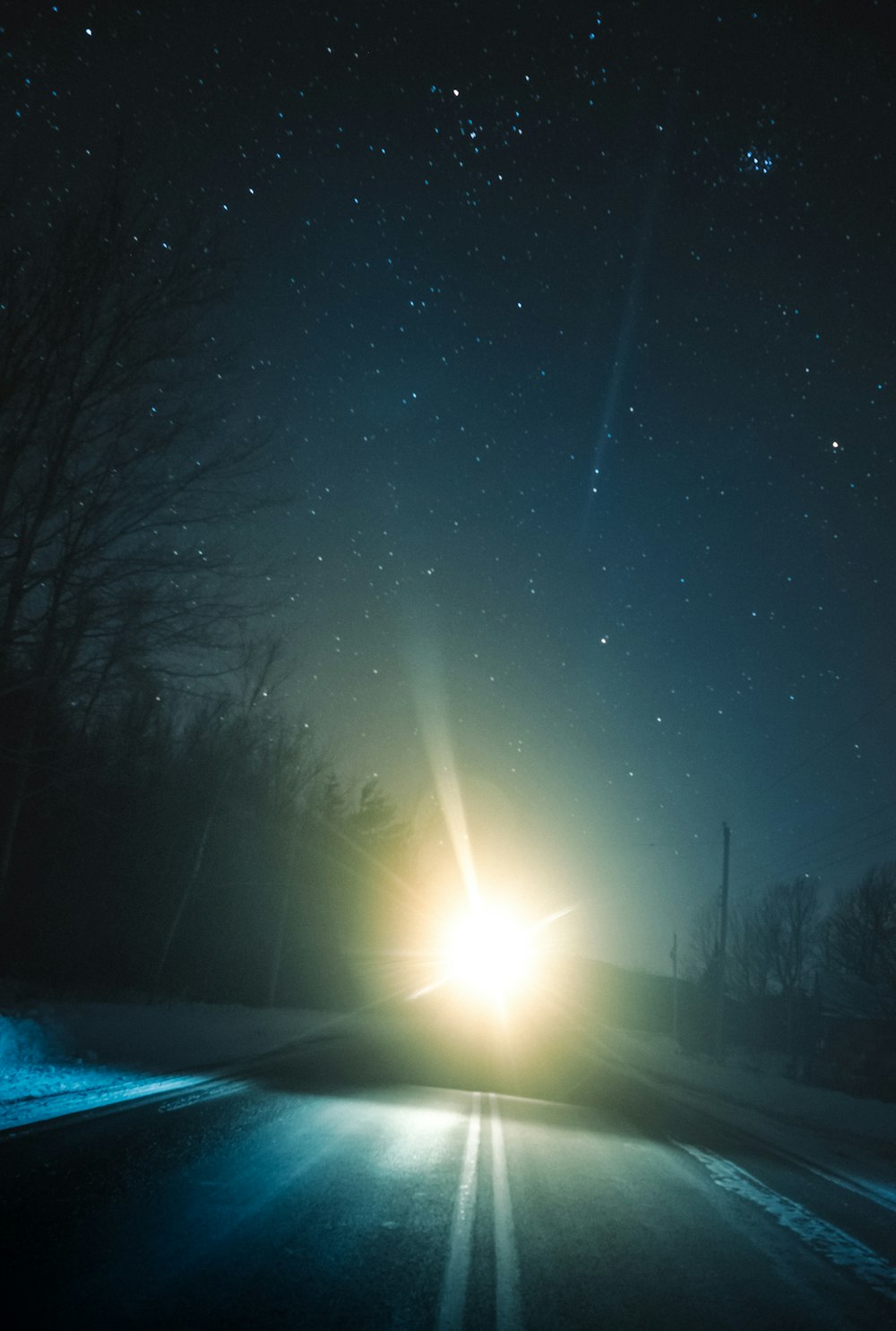 sun rays over trees and road