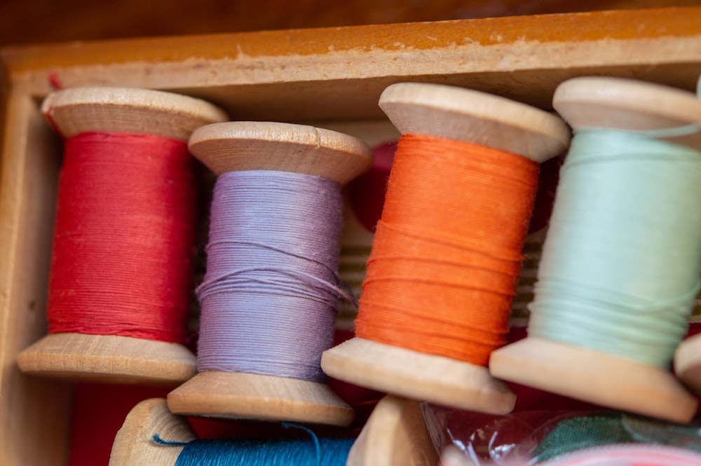 blue and red thread on brown wooden rack